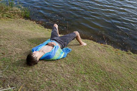 躺在河岸上的十几岁男孩图片