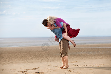 在海滩上玩得好开心的夫妇背景