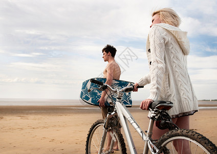 在海滩骑着自行车的情侣图片