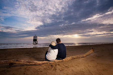 在海滩上看日落的夫妇图片