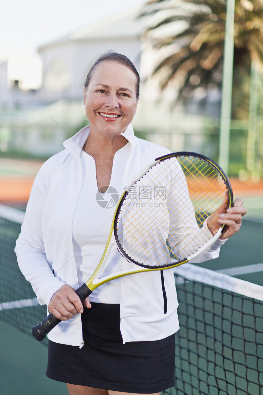 在球场上拿着网球拍的老妇人图片
