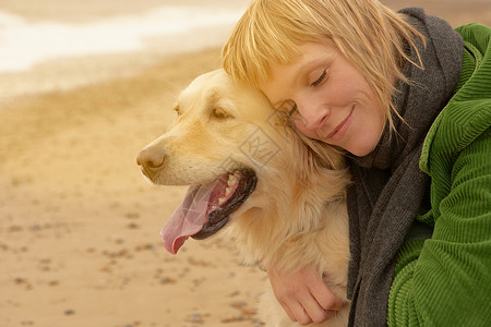 狗闭眼海滩上抱着狗的女人背景