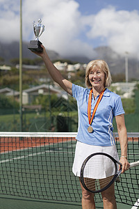 网球场上拿奖杯的老妇人图片