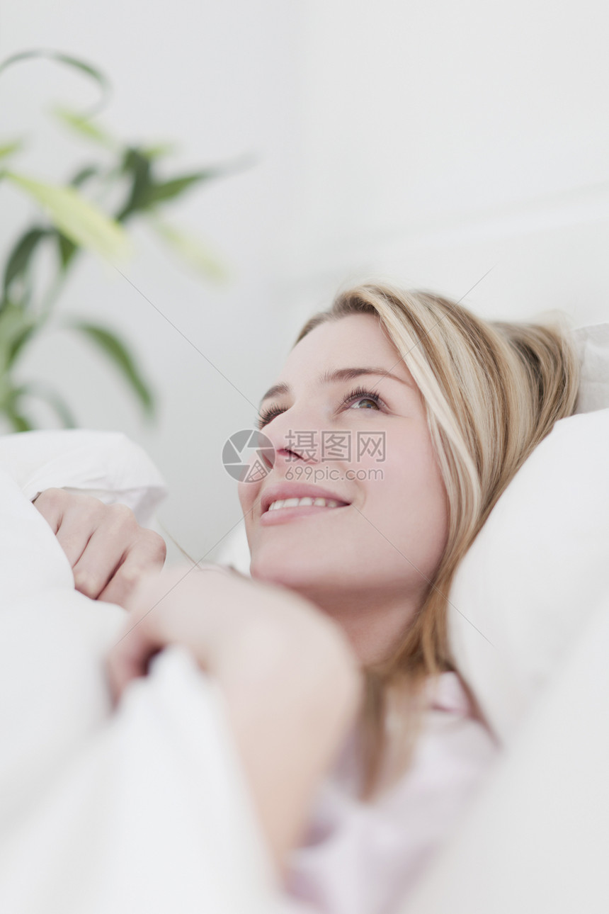 微笑的女人躺在床上图片