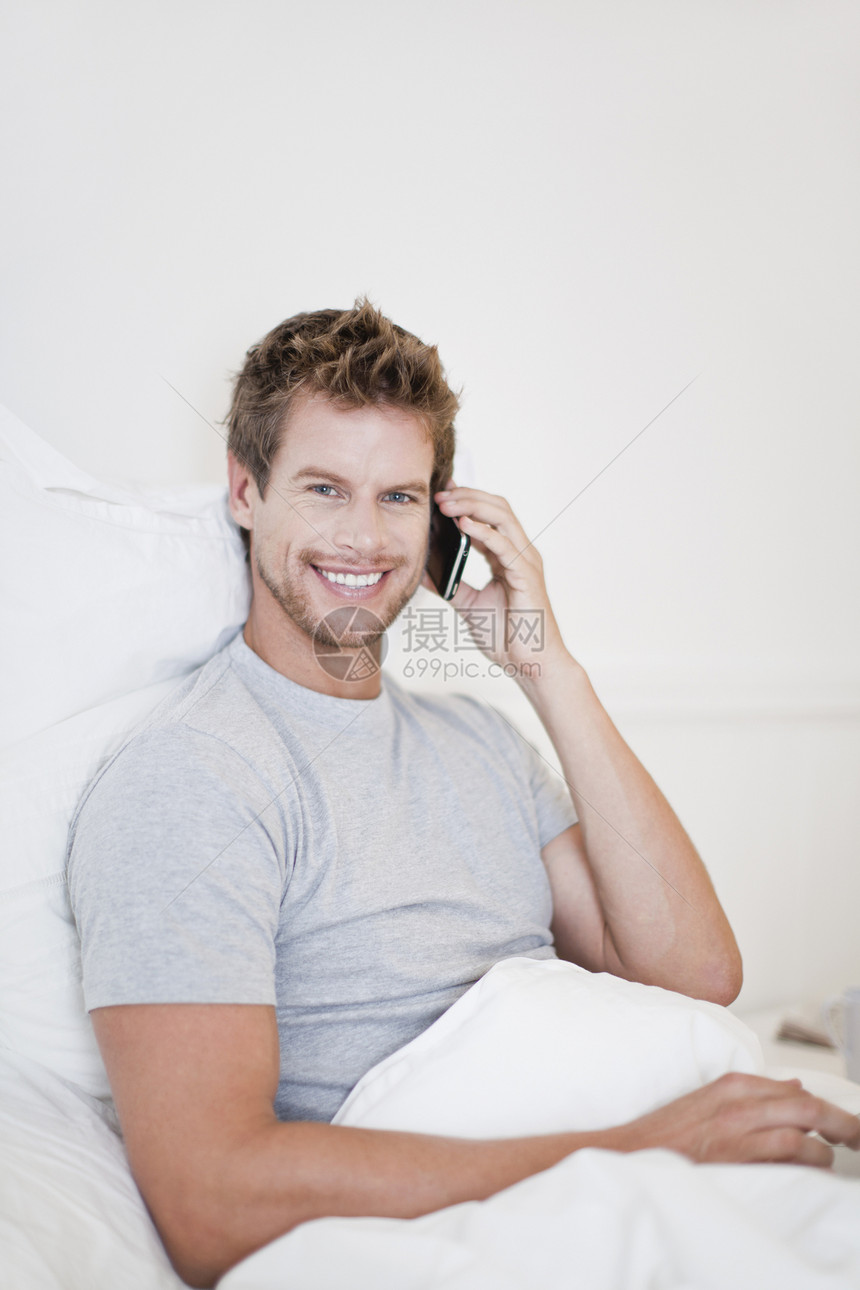 在床上打手机的男人图片