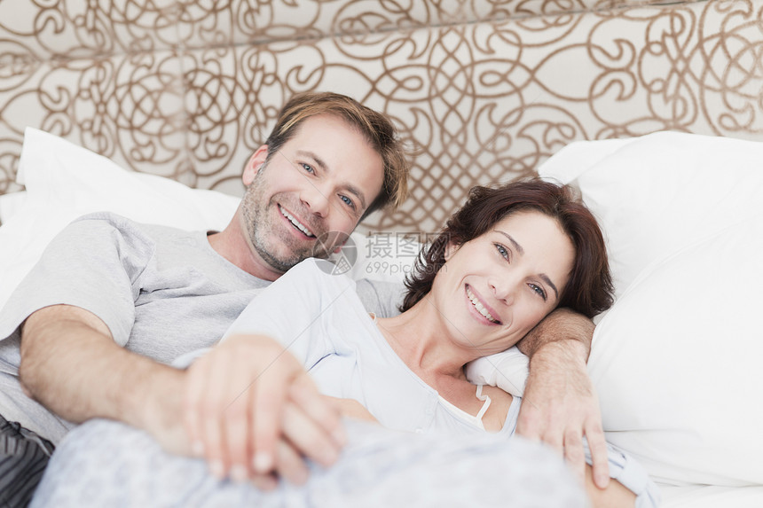 微笑的情侣在床上放松图片