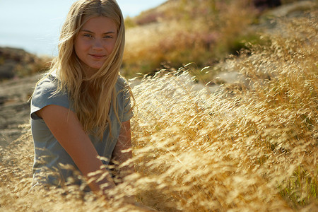 坐在草里的年轻女子图片