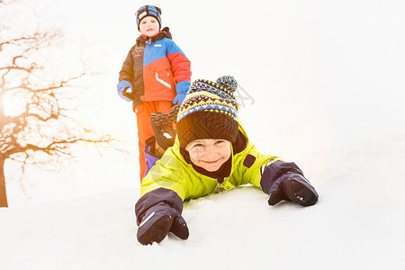 男孩和朋友躺在雪地里图片