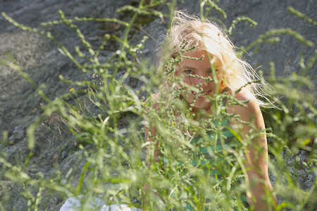 躲在灌木丛后面的年轻女人图片