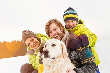 雪地里孩子父亲和儿子带着狗在雪地里背景