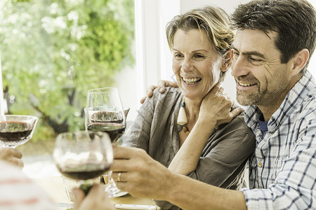 在餐桌上用红酒祝酒的夫妇背景图片