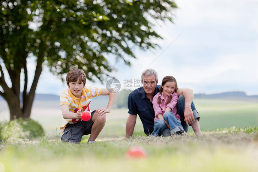 坐在草地上的三口之家图片