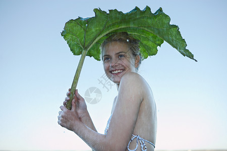 用树叶避雨的女子图片