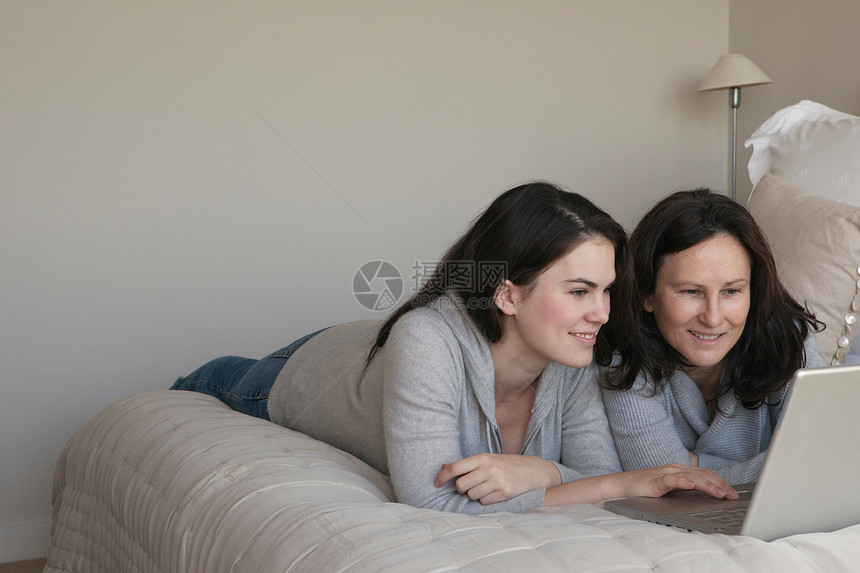 妈妈和女儿看着笔记本电脑图片