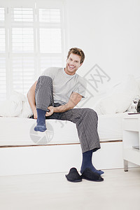 男人在床上穿袜子图片