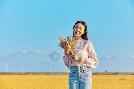 田埂年轻美女手拿花背景