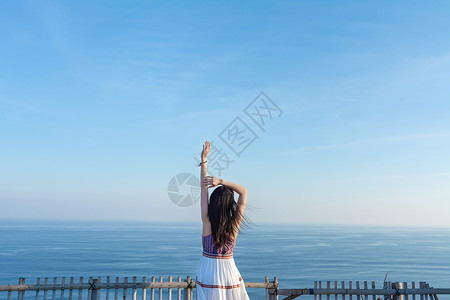 攀崖巴厘岛情人崖上的少女背影背景