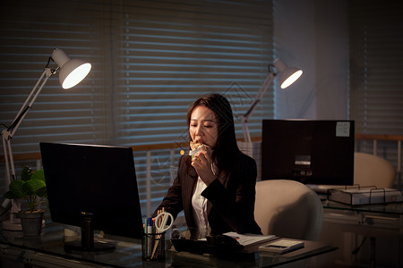 职场女性深夜加班吃三明治高清图片