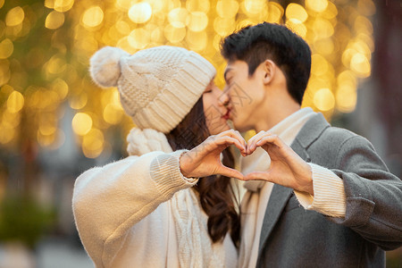 冬季情侣光斑下接吻比爱心高清图片