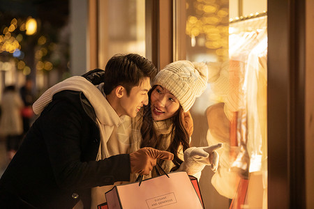 冬季情侣购物橱窗前挑选衣服高清图片