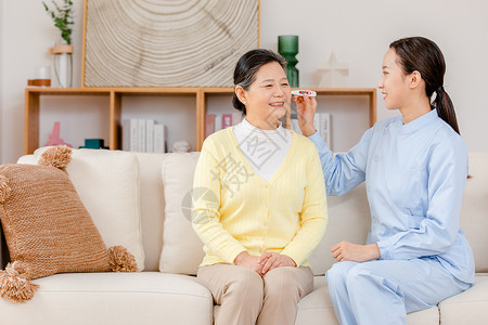 女性量体温护工给老人量体温背景