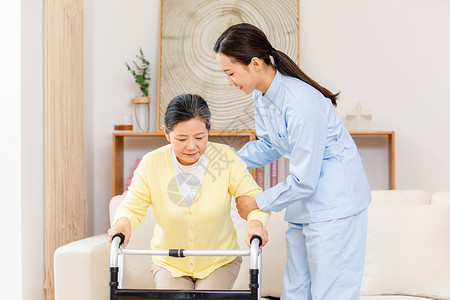 使用帮助护工扶着使用健步器的老奶奶锻炼身体背景