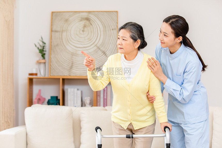护工扶着使用健步器的老奶奶锻炼身体图片