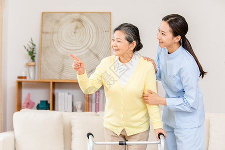 老年人锻炼身体护工扶着使用健步器的老奶奶锻炼身体背景