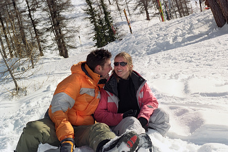 一对夫妇坐在雪地里笑着图片