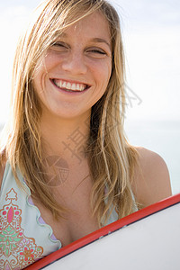 拿着冲浪板微笑的女孩背景图片