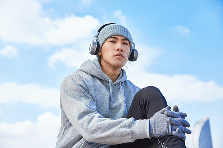 运动男青年带耳机听音乐高清图片