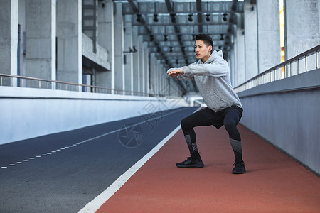 年轻男性户外运动男青年户外运动热身深蹲背景