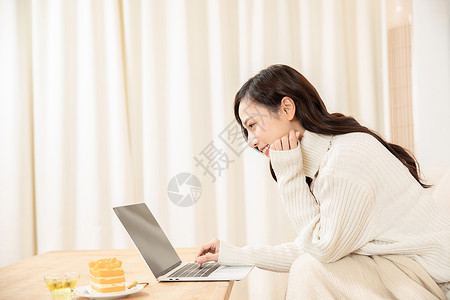 冬季居家女性笔记本电脑工作背景图片