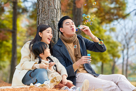 吹泡泡背景一家三口在公园吹泡泡背景