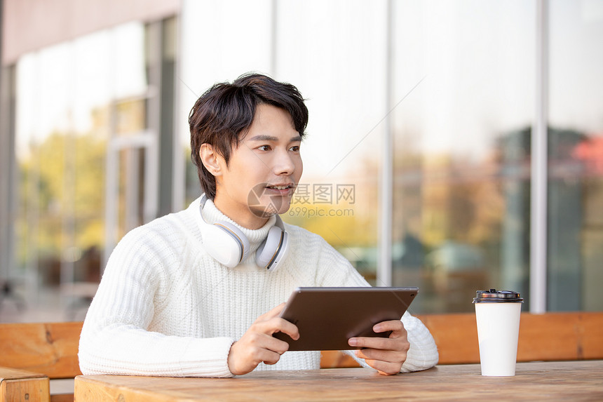 青年男性户外使用平板电脑图片