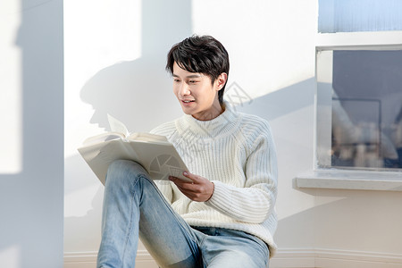 男孩坐在阳台上坐在阳台看书的男青年背景