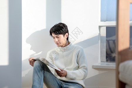 居家男性坐在阳台上看书高清图片