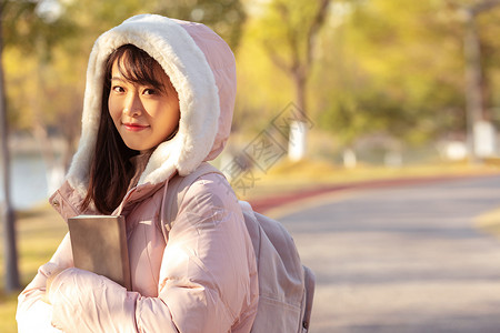 冬季校园里的甜美女大学生背景图片