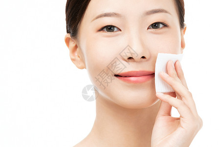 女性使用化妆棉擦拭面部 图片
