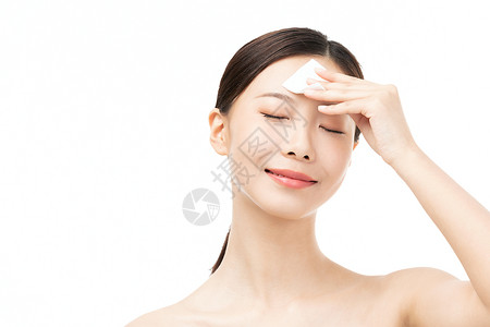 女性使用化妆棉擦拭面部高清图片