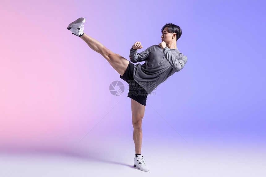 青年男性运动员高抬腿踢腿图片