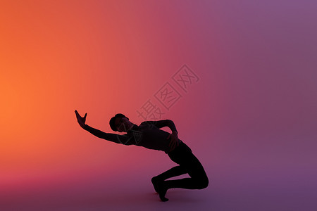 男性舞者下腰动作剪影背景图片