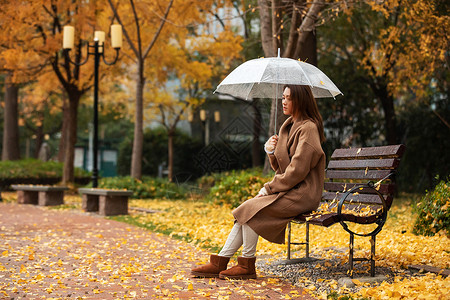 秋季雨天美女公园撑伞图片