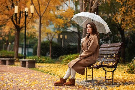 秋季雨天美女公园撑伞高清图片