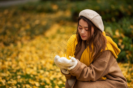 棉花少女秋季文艺美女手捧银杏叶背景