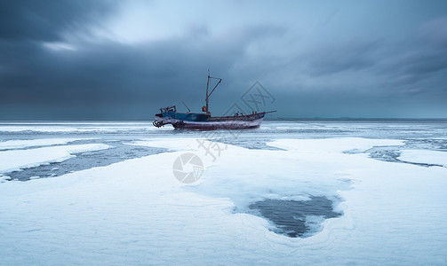 雪家海面结冰停泊的渔船背景