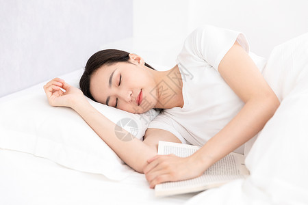 青年居家女性看书睡着图片