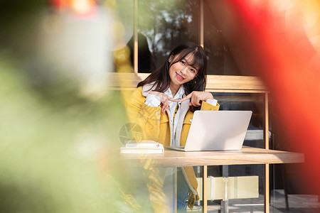 坐在咖啡厅使用笔记本的女大学生 图片