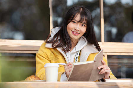 在咖啡馆写作业的女大学生图片