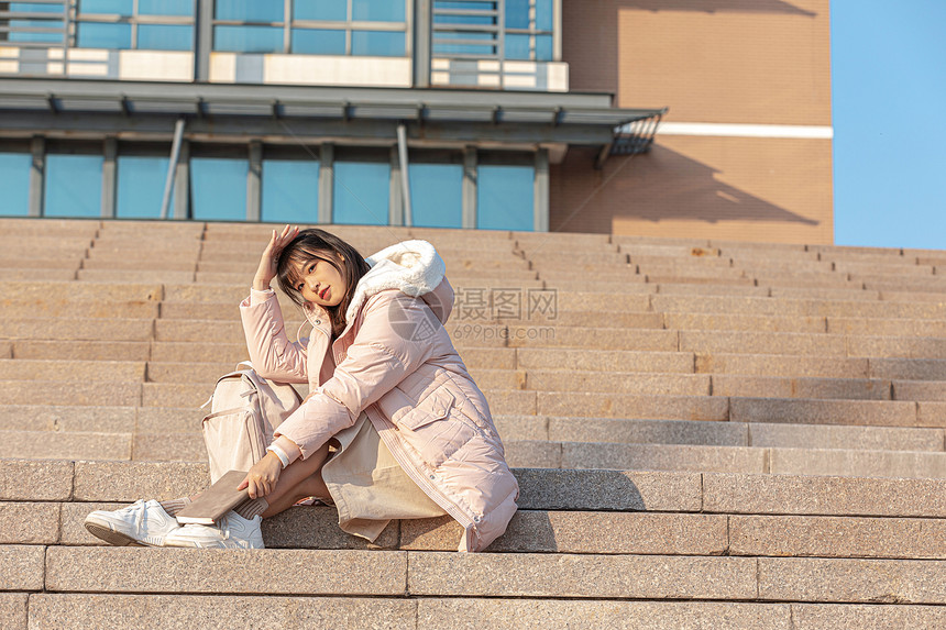 坐在户外台阶上的女大学生图片